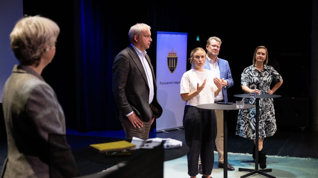 De fire foredragsholderne fra debatten på scenen. Debattleder Cornelia Kristiansen står med ryggen til.