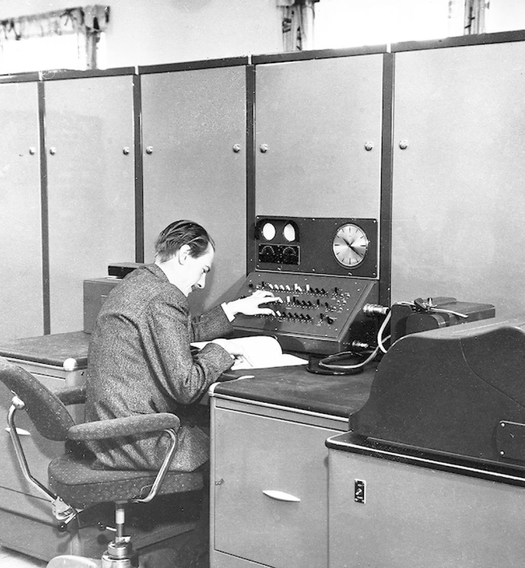 Harald Keilhau sitter ved FFIs første digitale datamaskin med 2000 vakuumrør og 20 kW varmetap. Ferranti Rapid Electronic Defence Research Institute Computer (FREDRIC) representerte et gjennombrudd i hvordan forskerne løste kompliserte matematiske problemer. 