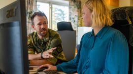 To personer foran en dataskjerm.