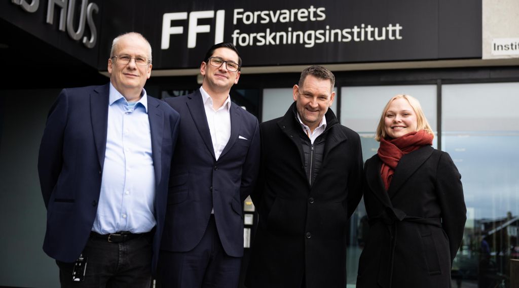 Gruppebilde av Arild Bergh (FFI), Peter Vinje-Banfield, Geir Holmefjord og Silje Lensu Dåbakk (FFI) foran inngangspartiet til FFI. 