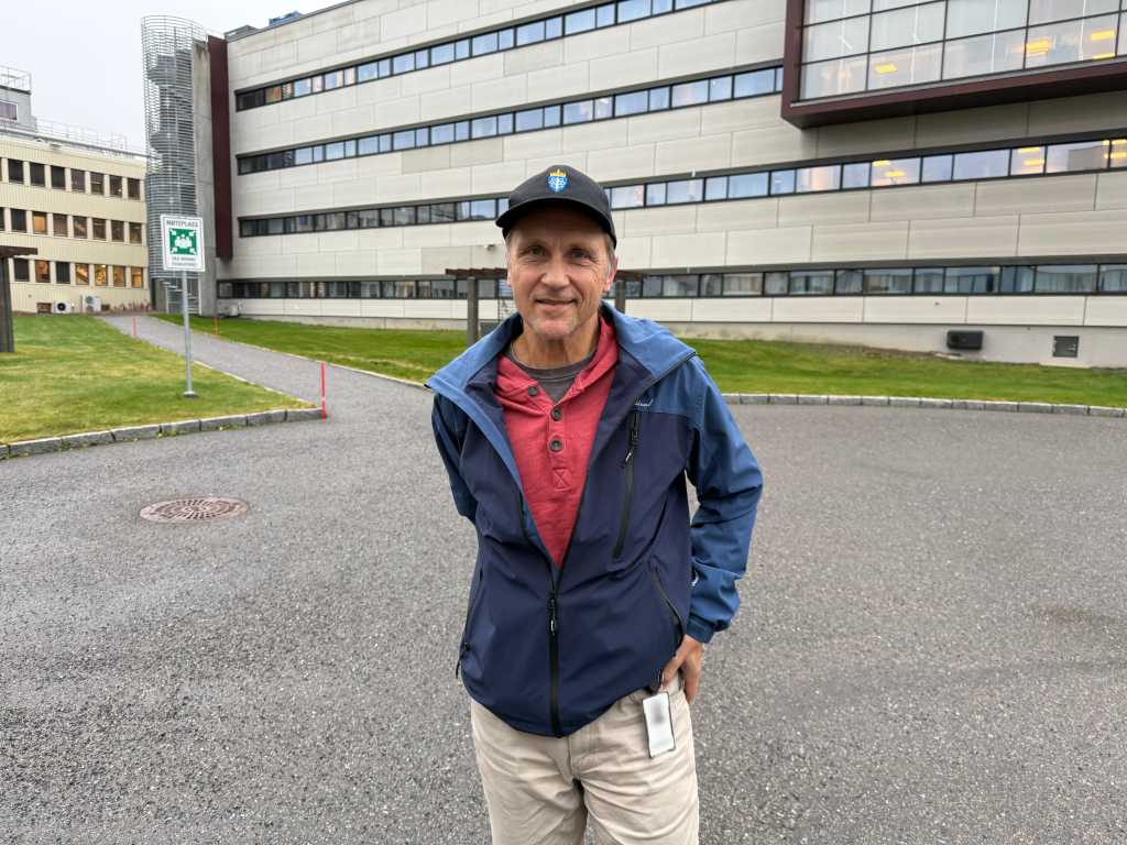 Portrett av forsker utendørs med FFI-bygniger i bakgrunnen.