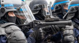 Paris, France - April 6, 2023: French police aiming with an LBD 40 mm blast ball riot gun, a kind of less lethal weapon launching rubber balls meant to be used against rioters or aggressive crowds