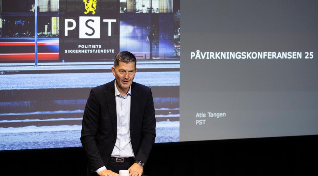 Atle Tangen i PST foran en presentasjon som viser logoen til Politiets sikkerhetstjeneste.