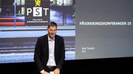 Atle Tangen i PST foran en presentasjon som viser logoen til Politiets sikkerhetstjeneste.