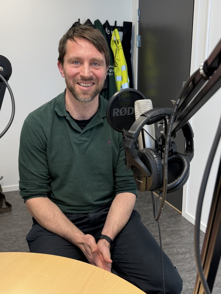 Portrett av Espen Åkervik foran mikrofonen i podkaststudio.