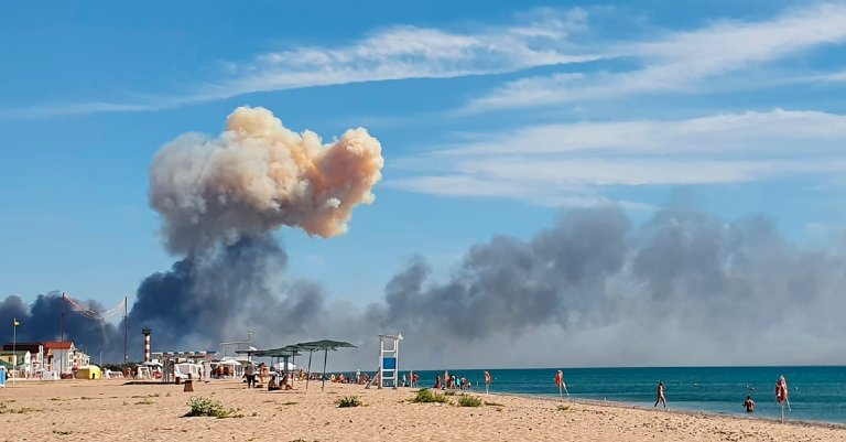 Røysky fra en eksplosjon stiger opp over strand med badegjester ved Novofedorivka på Krim 9. august.