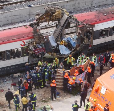 Rescue workers cover up bodies alongside a bomb-damaged passenger train, following a number of explosions in Madrid, Spain, March 11, 2004, just three days before Spain's general elections, killing more than 170 rush-hour commuters and wounding more than 500 in Spain's worst terrorist attack ever. (AP Photo/Paul White)