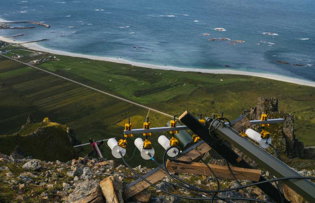 Nærbilde av en antenne i fjellet over Bleik på Andøya. Antennen består av flere hvite antenner som peker mot Bleik.