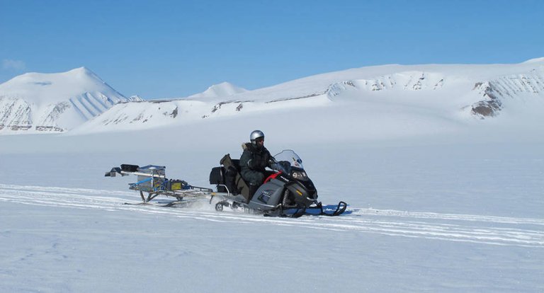 A test model of the RIMFAX instrument – aboard the trailer behind the snow mobile – undergoes field testing in Svalbard, Norway.