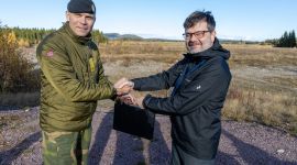 Two men shaking hands. Outside. Autumn.