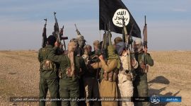 A group of IS soldiers with weapon and an IS flag.