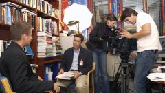 Researcher being interviewd on camera inside his office