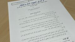 Paper document with arabic text laying on table