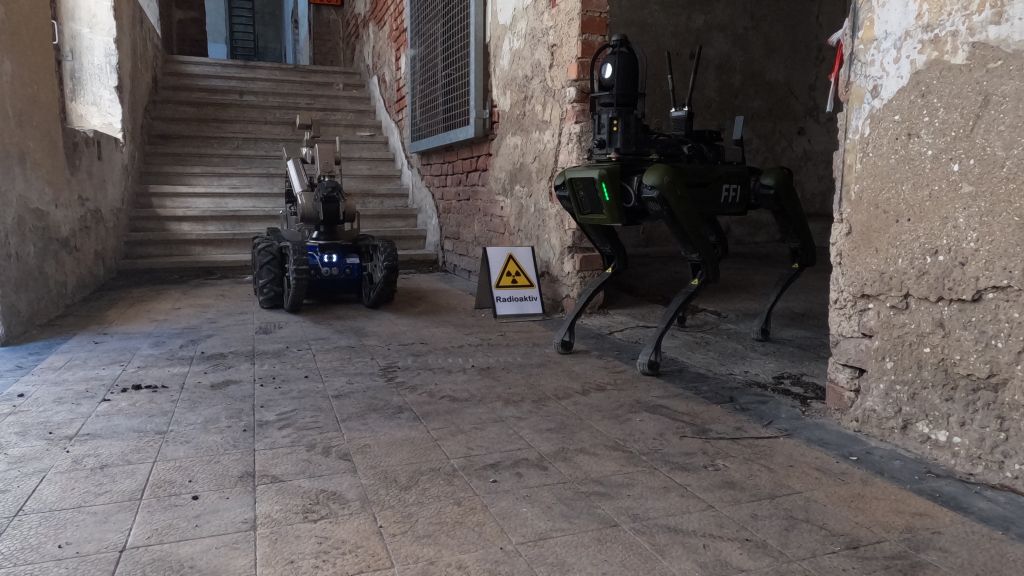 Robothund og selvkjørende beltevogn i steintrapp. Foto