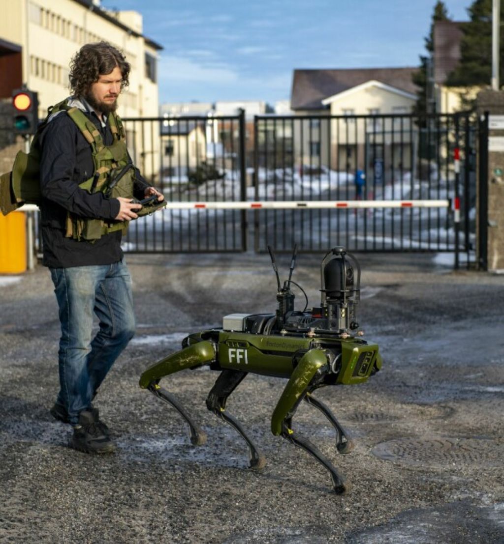Robothund går ute sammen med mann med fjernkontroll. Foto