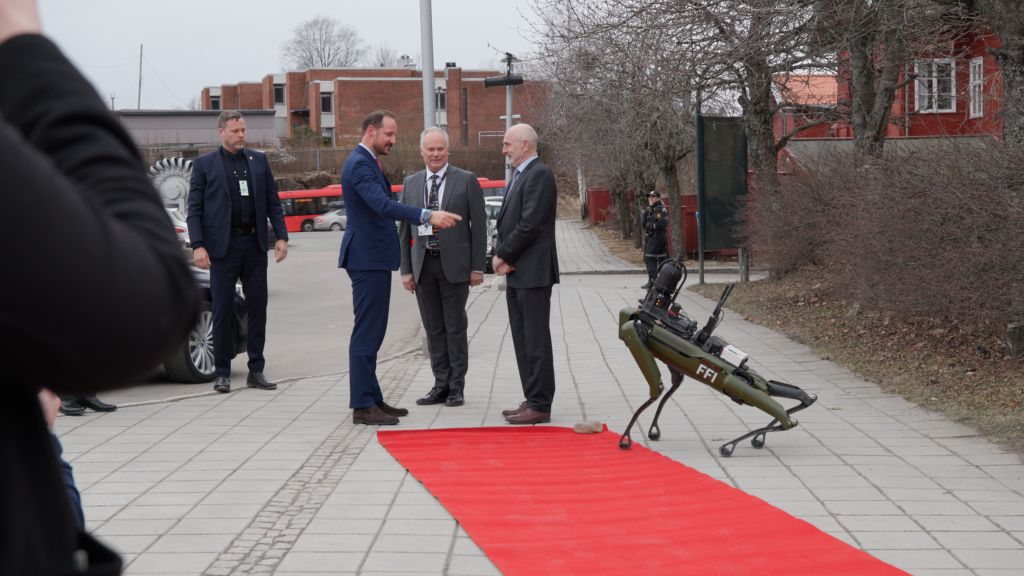 Robothund hilser på kronprinsen på rød løper. Foto