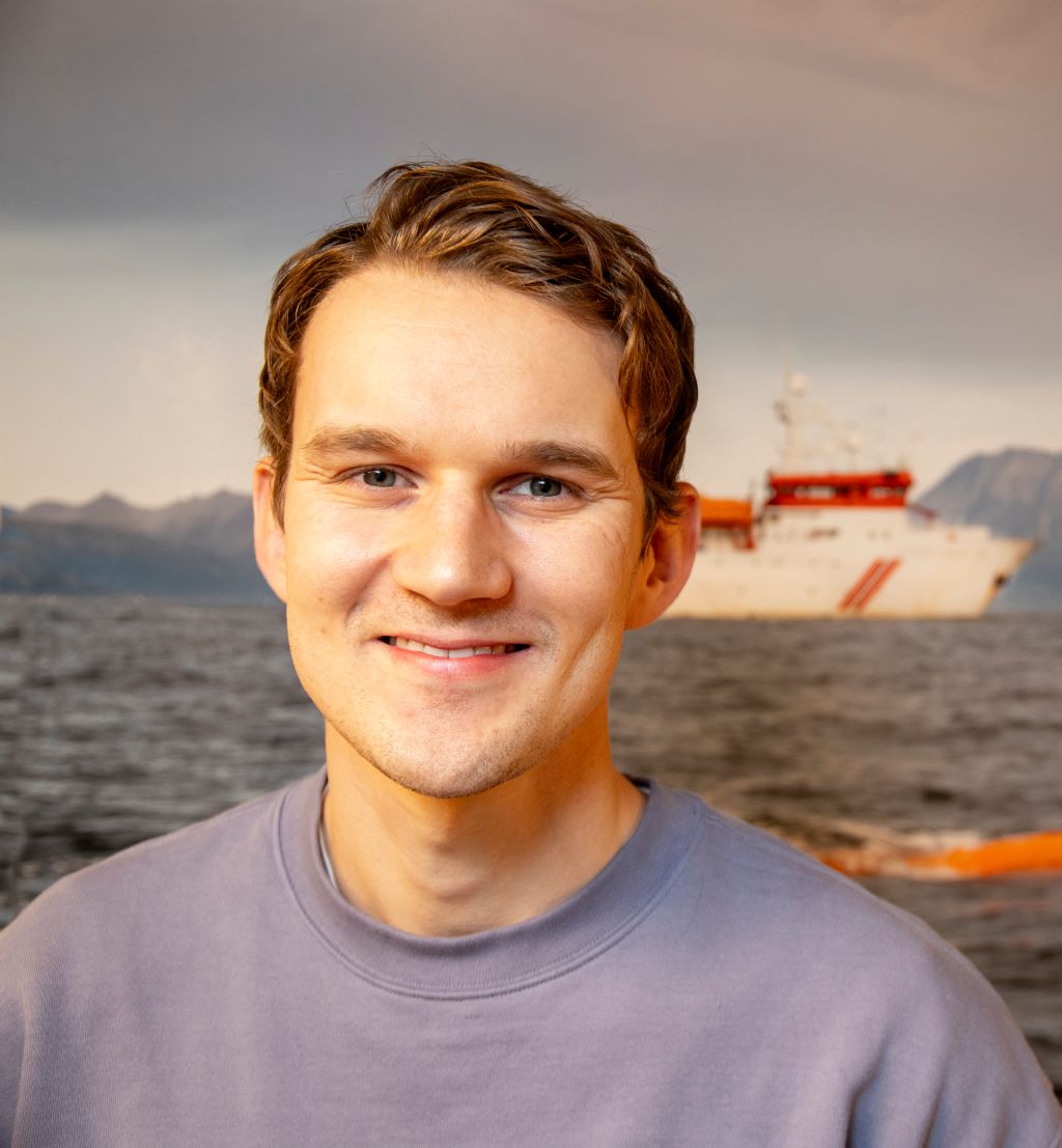 FFI-forsker Jens Einar Bremnes foran et bilde som viser Hugin i aksjon.
