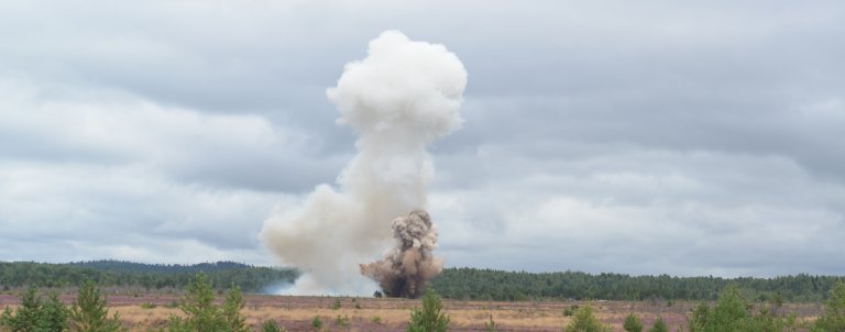 Røyksky fra veibombe i flatt landskap