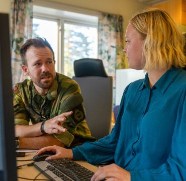 To personer foran en dataskjerm.