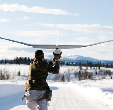 Soldat sender drone av gårde i vinterlandskap