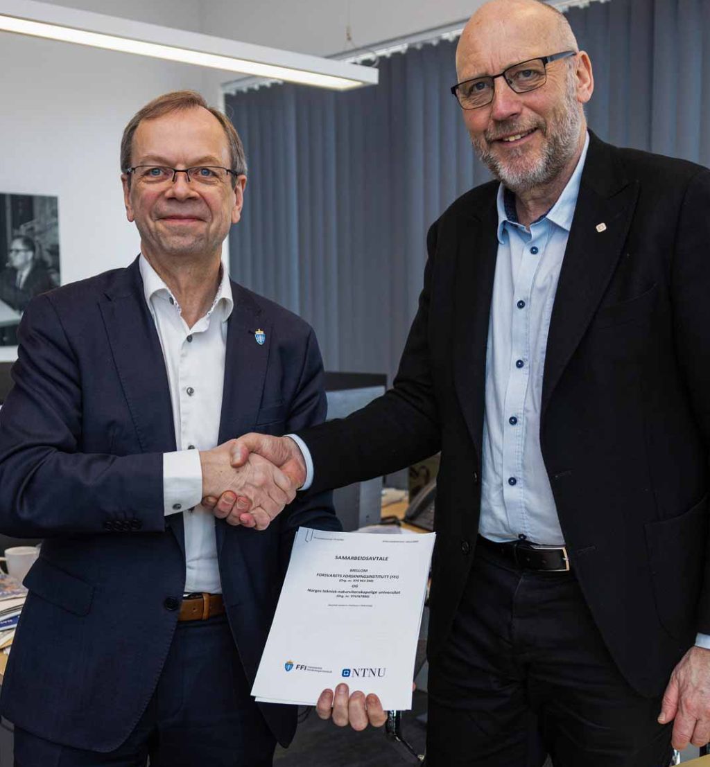 Kenneth Ruud og Tor Grande tar hverandre i hånden etter å ha signert avtalen.
