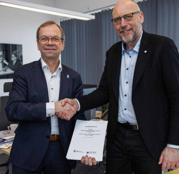 Kenneth Ruud og Tor Grande tar hverandre i hånden etter å ha signert avtalen.