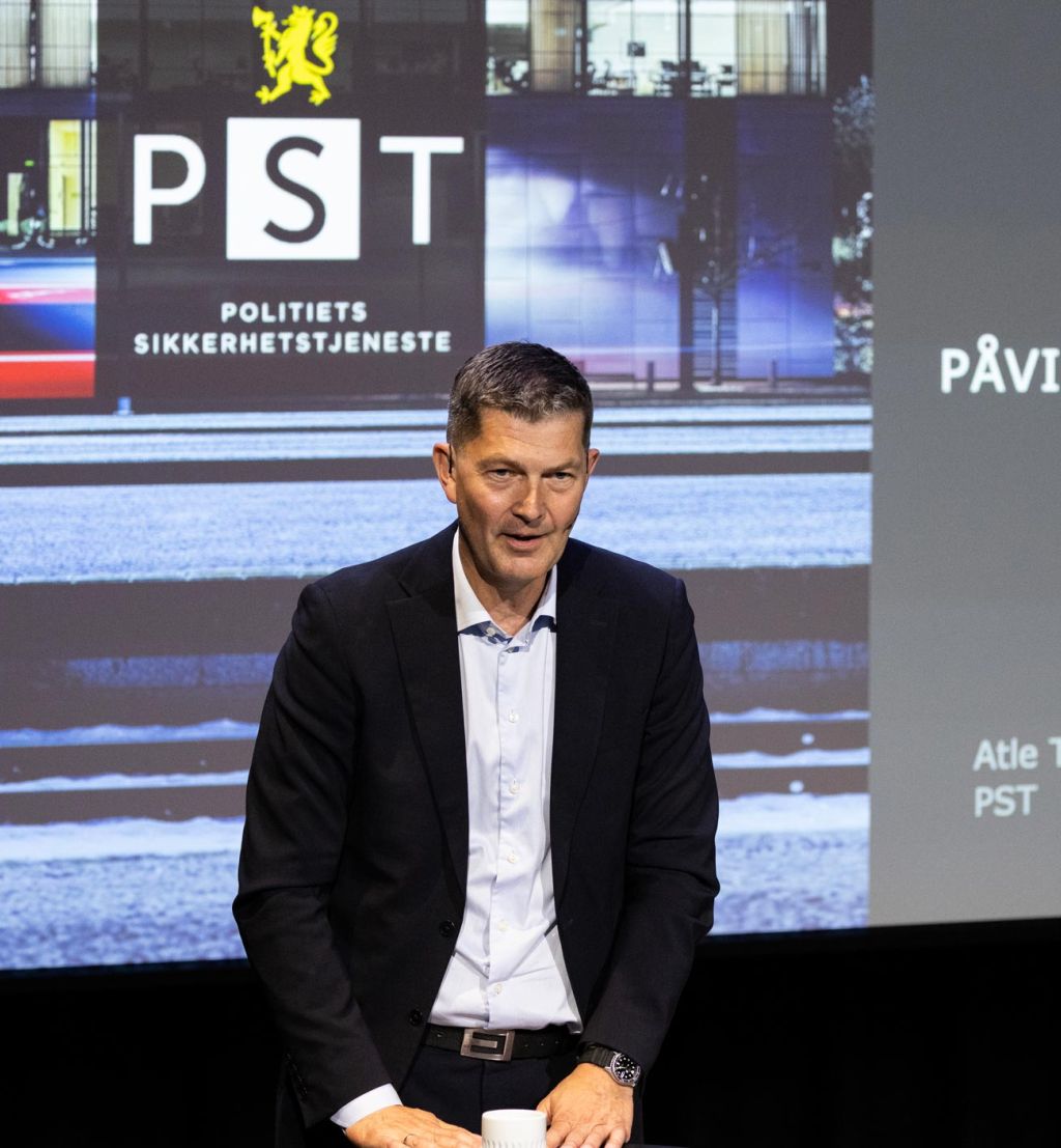 Atle Tangen i PST foran en presentasjon som viser logoen til Politiets sikkerhetstjeneste.