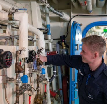personell fra sjøforsvaret som skrur på noen ventiler inne på fartøyet
