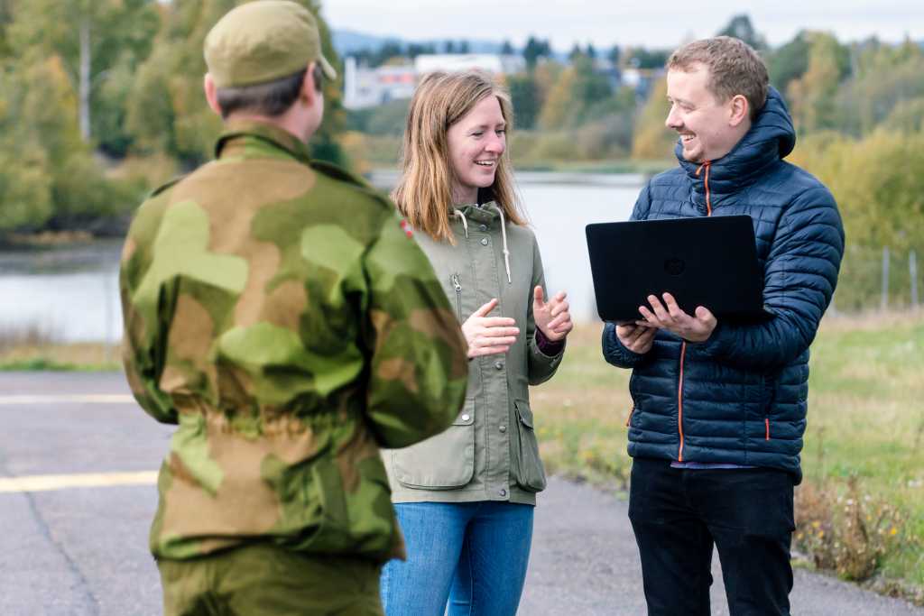 Forskere og soldat i samtale