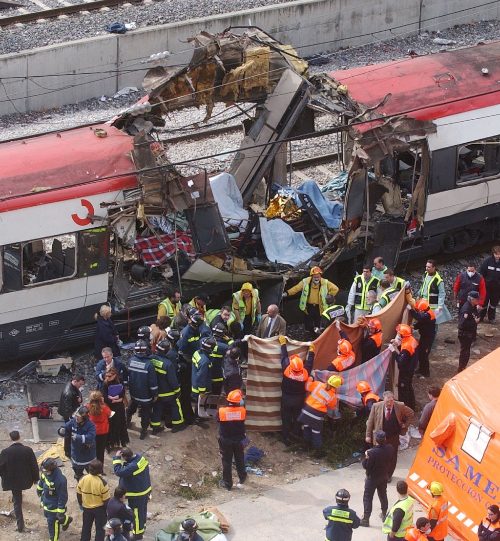 Hjelpearbeidere dekker til ofre etter terrorbombene som gikk av på penldertog i Madrid om morgenen 11. april 2004.