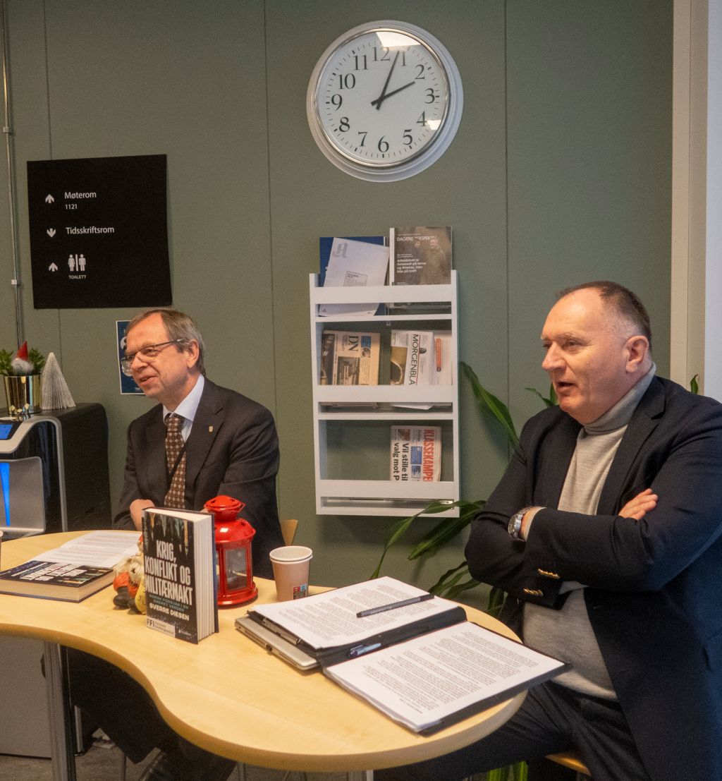 to menn i dress som sitter ved et bord