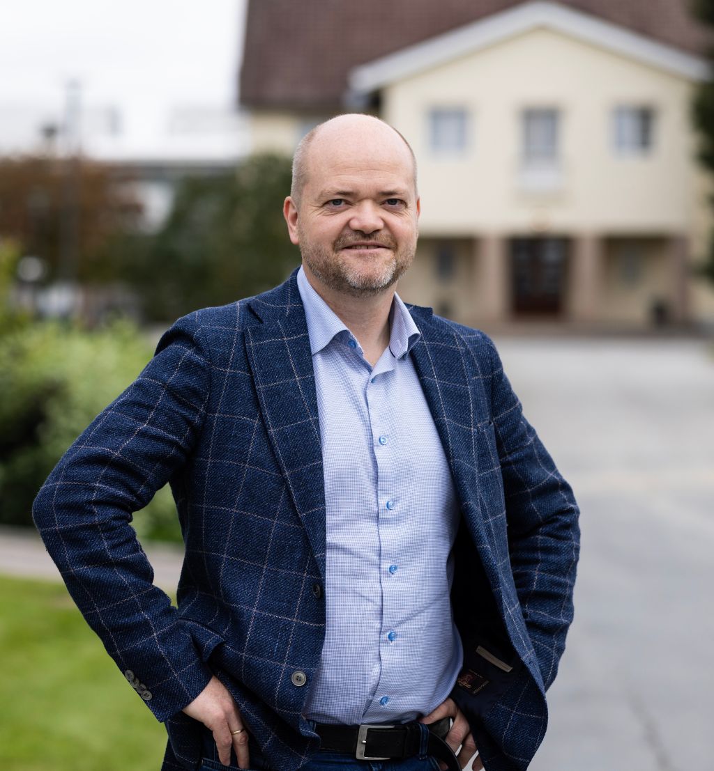 Karl Erik Olsen står utenfor et av byggene på Kjeller