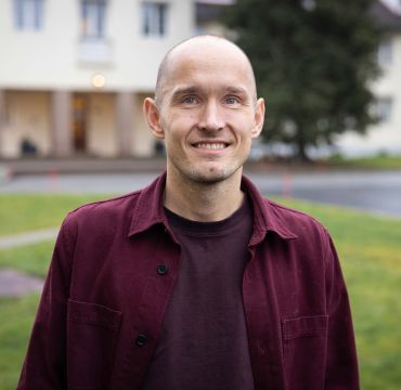 Nærbilde av Olger Breivik i burgunder skjorte.