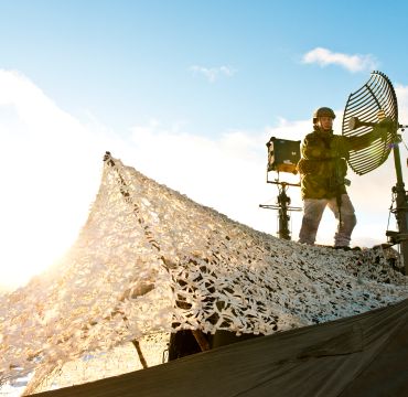 På grunn av kraftig vind, må antennene til knutepunktslaget i Sambandsbataljonen justeres jevnlig. /Soldiers from Signal Battalion adjust an UHF-antenna.