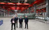 Fire dresskledde menn i en industrihall.