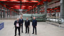 Fire dresskledde menn i en industrihall.