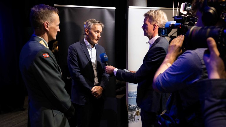 To menn intervjues av en journalist.