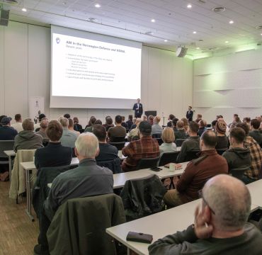 Publikum følger med på en presentasjon på storskjem.