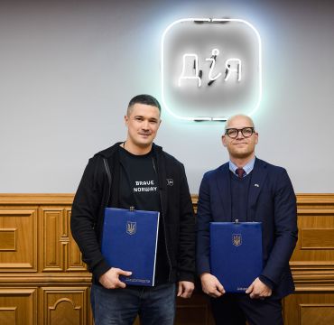 To menn holder hver sin mappe med samarbeidsavtale. Innendørs.