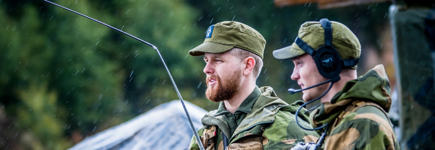 To militærkledde menn med samband på øret og nettbrett i hånda